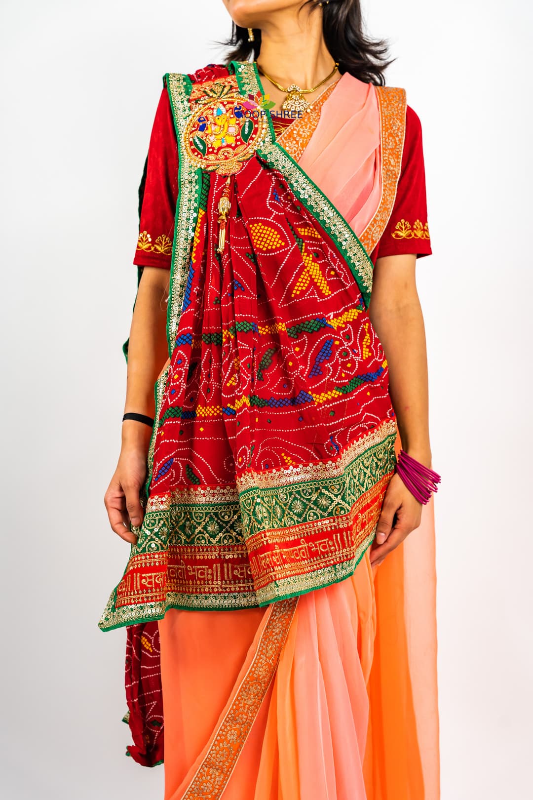 Traditional odhna adorned with Ganesh brooch for divine elegance.